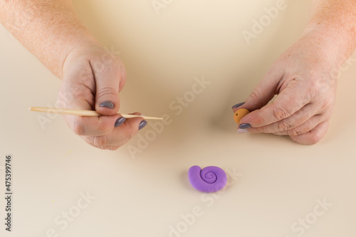 A snail made of polymer clay. Step-by-step instruction. Step 5 Roll up the head ball. photo