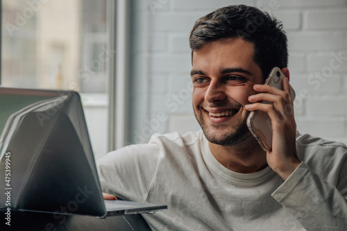 man at home with mobile phone and computer