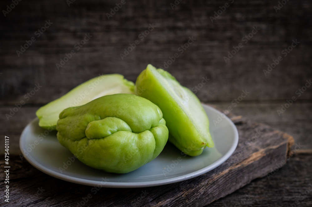 Fresh green prickly pumpkin, chayote on wooden background, (Sechium edulis) Fresh green prickly pumpkin, chayote on wooden background, (Sechium edulis)