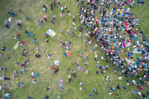 A concert in nature. A bunch of people listening to music sitting on the lawn. Shooting from a drone. photo