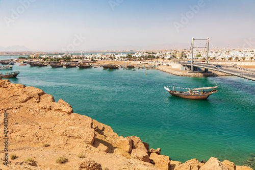 Middle East, Arabian Peninsula, Oman, Al Batinah South. Dhow passing under a suspension bridge.