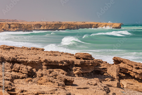 Middle East, Arabian Peninsula, Oman, Al Batinah South. Breaking surf along the rugged coast of the Arabian Sea. photo