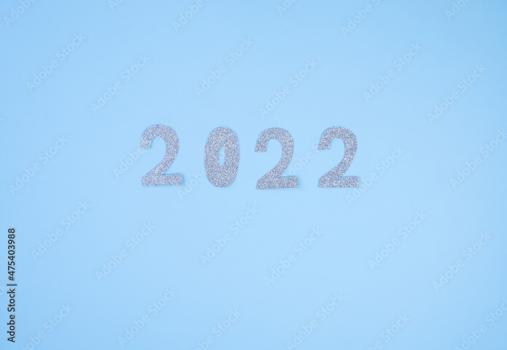 Naklejka premium Happy New Year 2022. Christmas background with silver glittering numbers 2022 on light blue background. View from above. Place for your text.