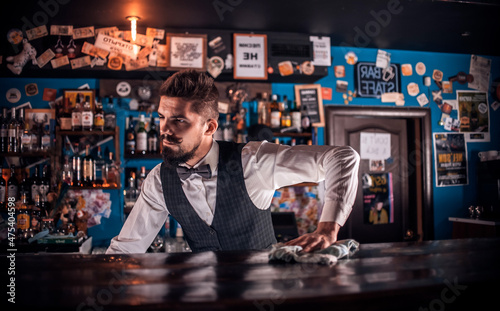 Young bartending demonstrates his professional skills at bar