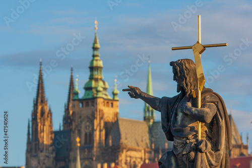 Statue of St. John the Baptist on the Charles Bridge with the Prague Castle and St. Vitus Cathedral the background, Prague, Capital city of Czech, UNESCO World Heritage Site, Czech Republic