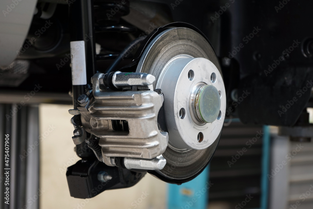 Brake disc and brake caliper installed on a modern car. Selected focus. The background is blurred.