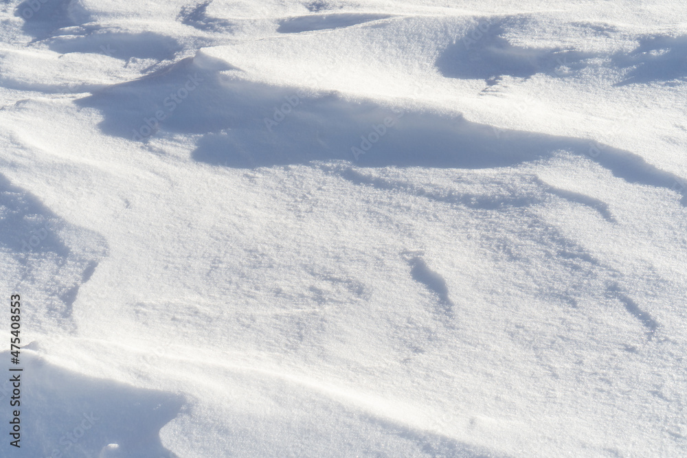 White natural snow texture with waves blown by the wind. Winter background. White natural snow texture with waves blown by the wind. Winter background.
