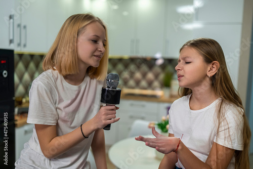 two teenage girls singing microphone at home fun.