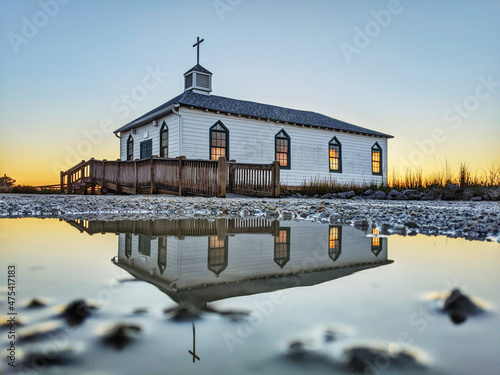 Beautiful scenery of Pawleys island chapel and its reflection with a sunset background photo