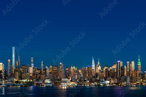 Aerial New York City skyline from New Jersey over the Hudson River with the skyscrapers of the Hudson Yards district at night. Manhattan  Midtown  NYC  USA. A vibrant business neighborhood