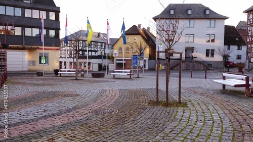 Usingen, Germany, November 2021: European medieval architecture of modern city in half-timbered style, cars driving on road in city center, concept of cultural tourism, travel, excursions in old town photo