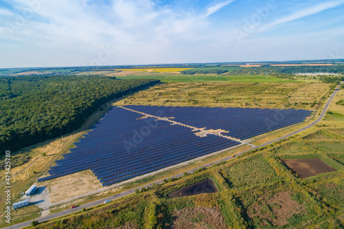 Solar power plant, solar panels shot from a drone, blue sky and clouds