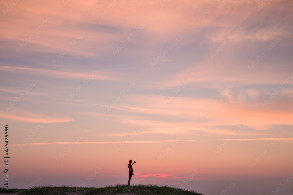 Sweden, Scania, Malmo, Riberborgs Stranden beach area, woman photographing selfie at sunset