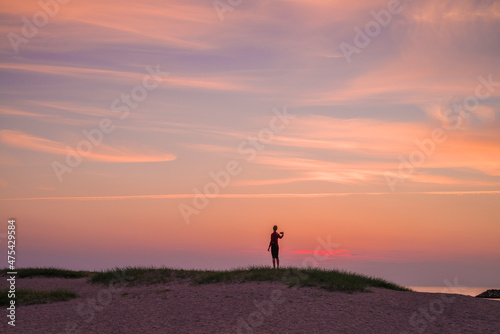 Sweden, Scania, Malmo, Riberborgs Stranden beach area, woman photographing selfie at sunset