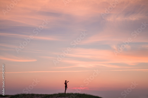 Sweden, Scania, Malmo, Riberborgs Stranden beach area, woman photographing selfie at sunset