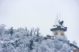 The famous clock tower on Schlossberg hill, in Graz, Steiermark region, Austria, with snow, in winter. Selective focus