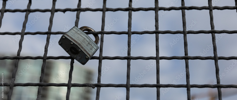 Obraz premium Padlocks hanging on a wire rope. Love locks on netting fence at the bridge in New Westminster BC.