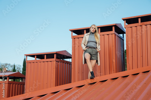 a beautiful woman looks at the city from the roof of the house