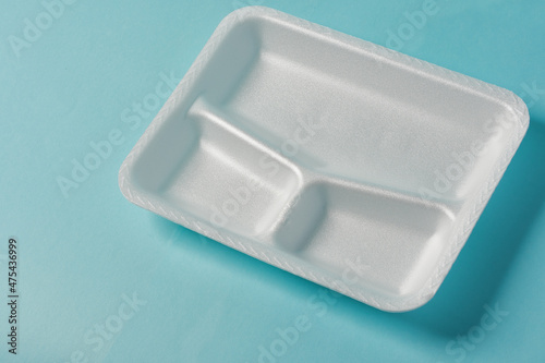 white Styrofoam plastic plates on blue background. Trash plastic, reusable plastic, disposable, for food. photo