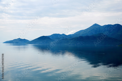 Calm tranquil blue lake on the edge of the mountains range. Scenic nature backgrounds