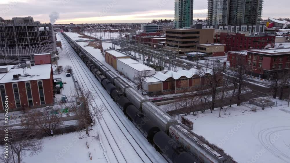 Train oil trailers passing trough City downtown Calgary winter snow following