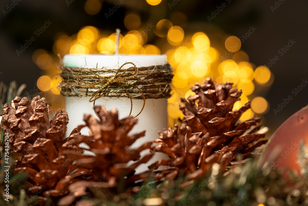 vela de Navidad y Adviento con bokeh dorado y conos de pino