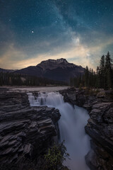 Waterfall with long exposure under a starry sky in the morning in Jasper National Park, Canada