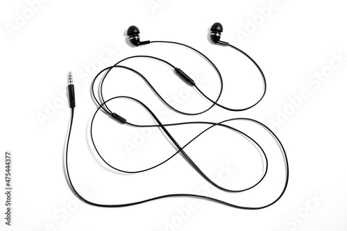 Black wired vacuum earplugs isolated on a white background. Headphones headset. In-ear headphones for listening music and sounds on portable devices.