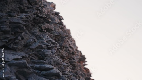 A close-up view of the rocky dolomite formations of the Trollholmsund in Norway. Chipped, jagged stones covered with lichen against the blue sky. photo