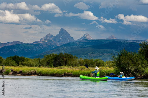 USA, Idaho. Two folks in inflatable kayaks enjoy Teton River, Teton Valley, Grand Teton in distance