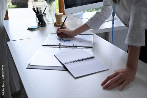 Woman office worker putting signature on business document.