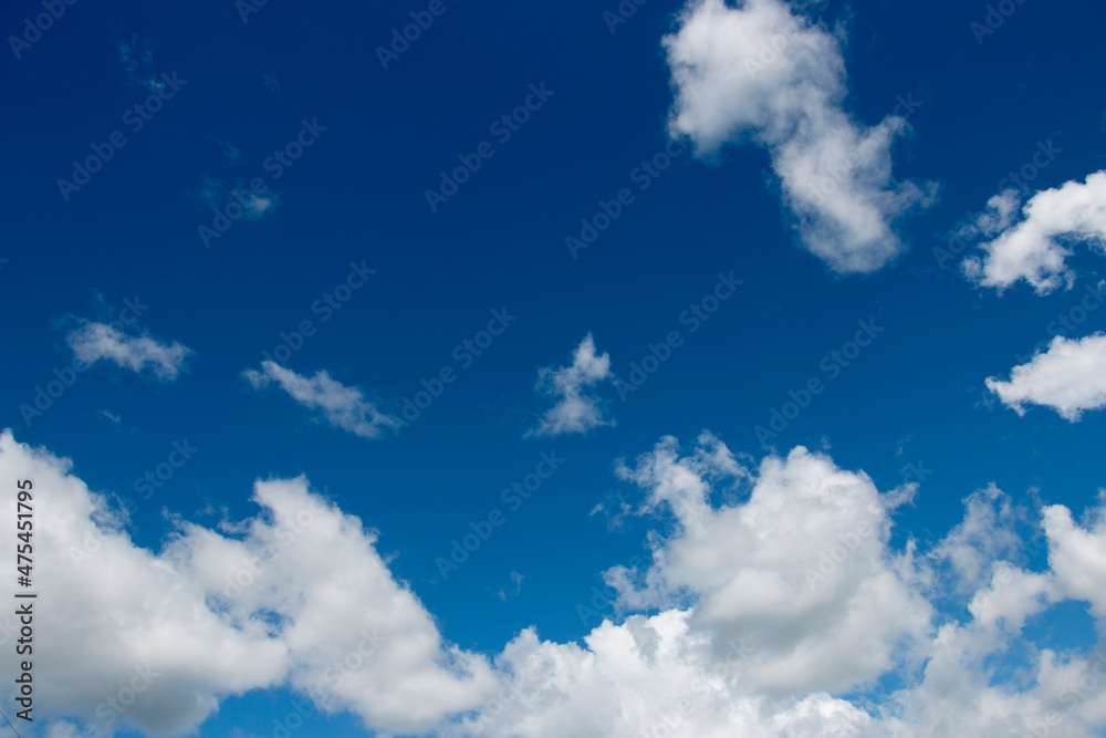 Fototapeta premium Blue, bright sky background with white clouds clouds.