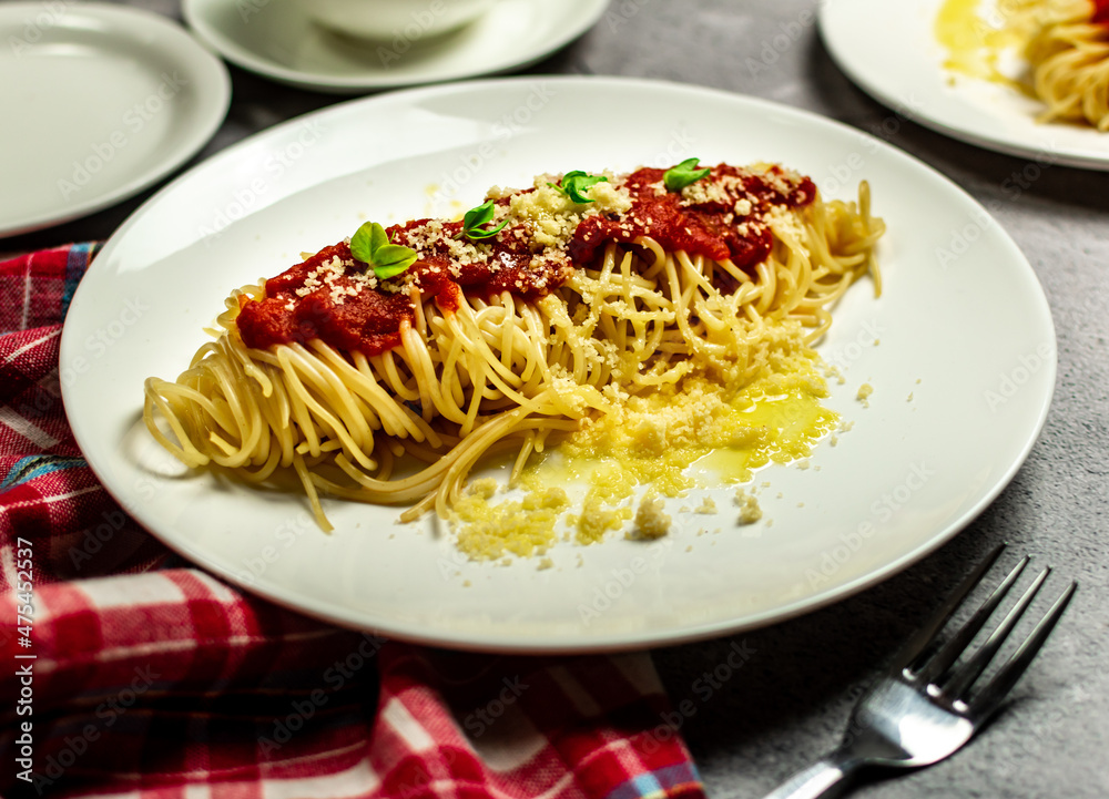 Delicious classic homemade spaghetti al pomodoro with a beautiful summer tomatoes. Served with parmesan cheese and fresh basil. Presented with copy space, top view. Delicious classic homemade spaghetti al pomodoro with a beautiful summer tomatoes. Served with parmesan cheese and fresh basil. Presented with copy space, top view.