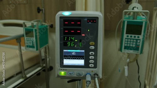 Low light footage with noise effect added of vital sign monitor used in a hospital.