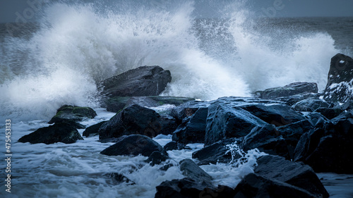 USA, New Jersey, Cape May National Seashore. Wave splashing on shore rocks.