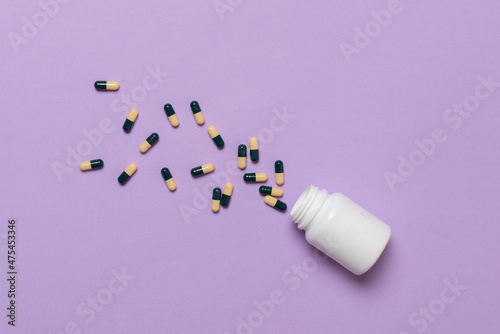 some medicine pills out of the plastic can package on the colorful surface flat lay