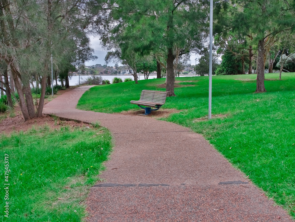 lonely park bench in a park Concord Bay with a winding footpath Sydney NSW Australia 