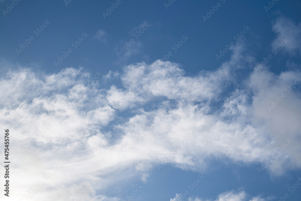 Background Texture of a clear blue sky, with an interesting white cloud pattern.