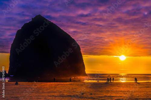 Colorful sunset, birds, Haystack Rock sea stack, Canon Beach, Clatsop County, Oregon. Originally discovered by Clark of Lewis Clark in 1805 photo