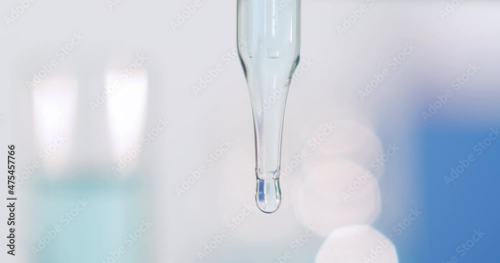 Pipette dropper with bubble and blurred bright background, cool fresh tones.