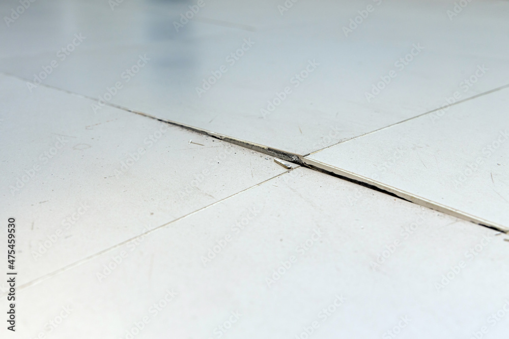Ceramic tiles floor cracked and broken from concrete inflate in house