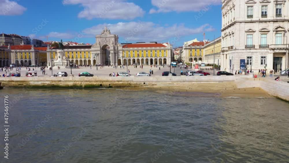 Aerial view low over the river in front of the Praca do Comercio in sunny Lisbon, Portugal - rising, tracking, drone shot Aerial view low over the river in front of the Praca do Comercio in sunny Lisbon, Portugal - rising, tracking, drone shot