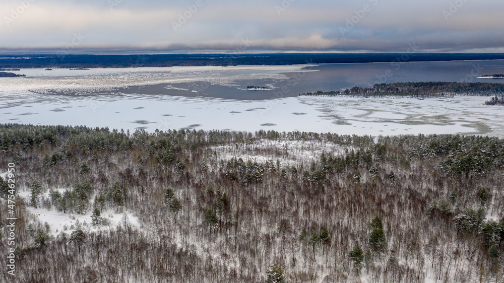 Winter landscape. Lake and ice. Island and forest. Snow and water. Winter landscape. Lake and ice. Island and forest. Snow and water.