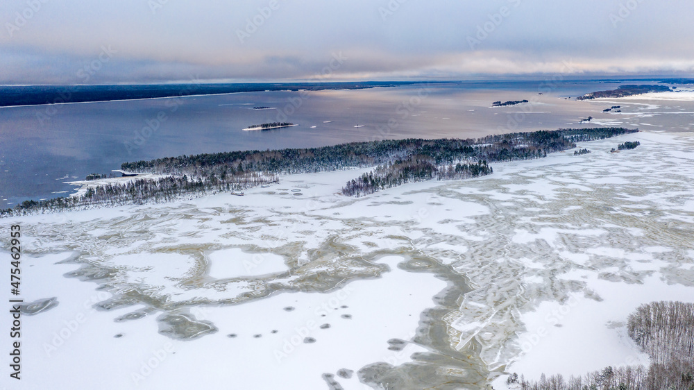 Winter landscape. Lake and ice. Island and forest. Snow and water.