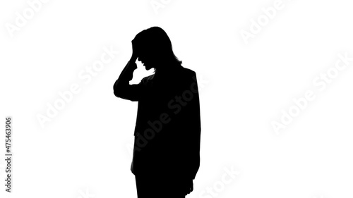 Photo of woman's silhouette in suit jacket with facepalm gesture