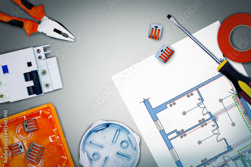 Electrical equipment, tools and schemes on grey surface. Top view.