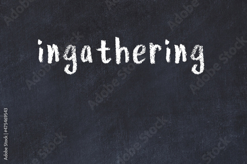 White wall with black paint inscription ingathering on it