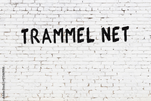 Foto White wall with black paint inscription trammel net on it