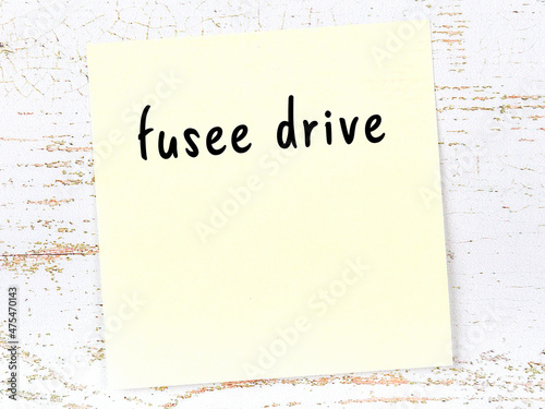 Yellow sticky note on wooden wall with handwritten word fusee drive photo