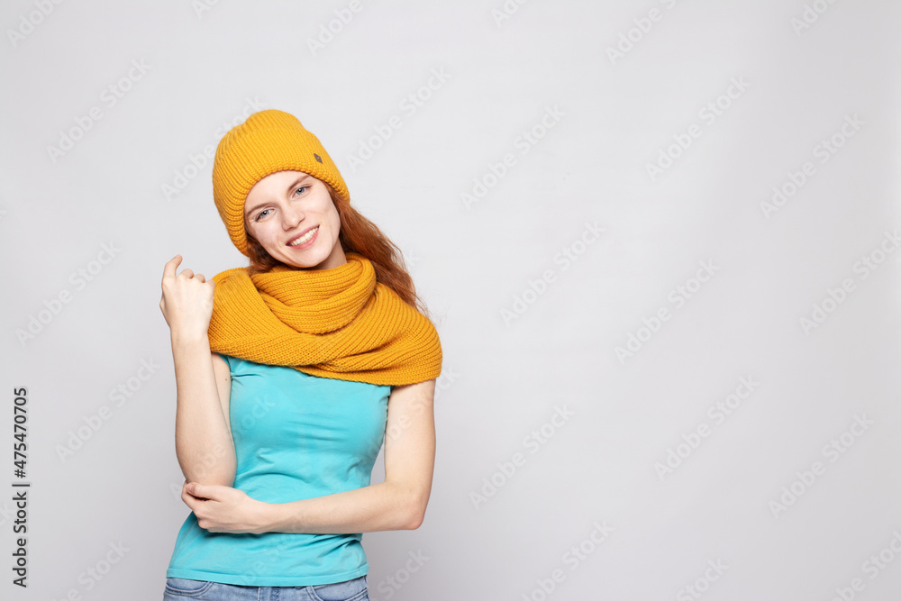 red-haired girl in a warm hat on a light background red-haired girl in a warm hat on a light background